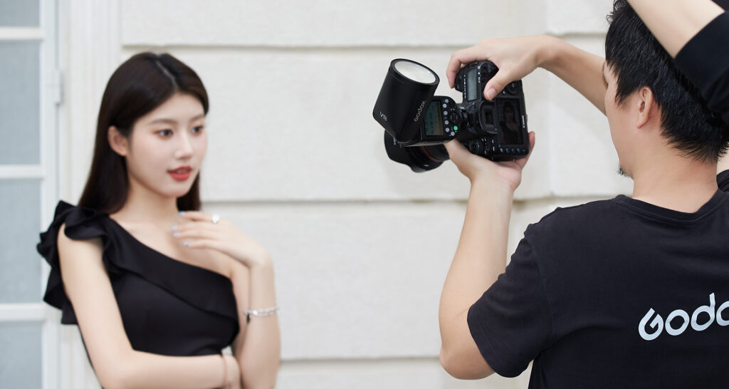 Photographer shooting with Godox V1Pro round head camera flash 