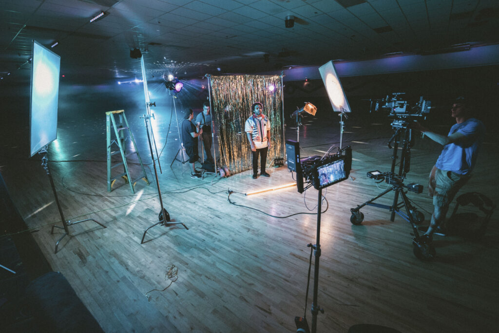 Professional filmmaking music video set with crew, cameras and lighting