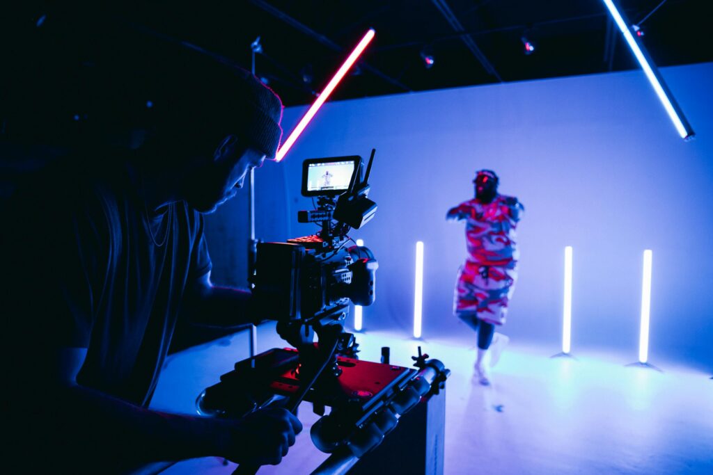 Cameraman recording a music dance video on a set with lighting LED tubes