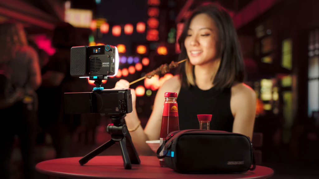 An influencer recording a video eating in a restaurant with amaran Ace 25x LED panel light used as fill light