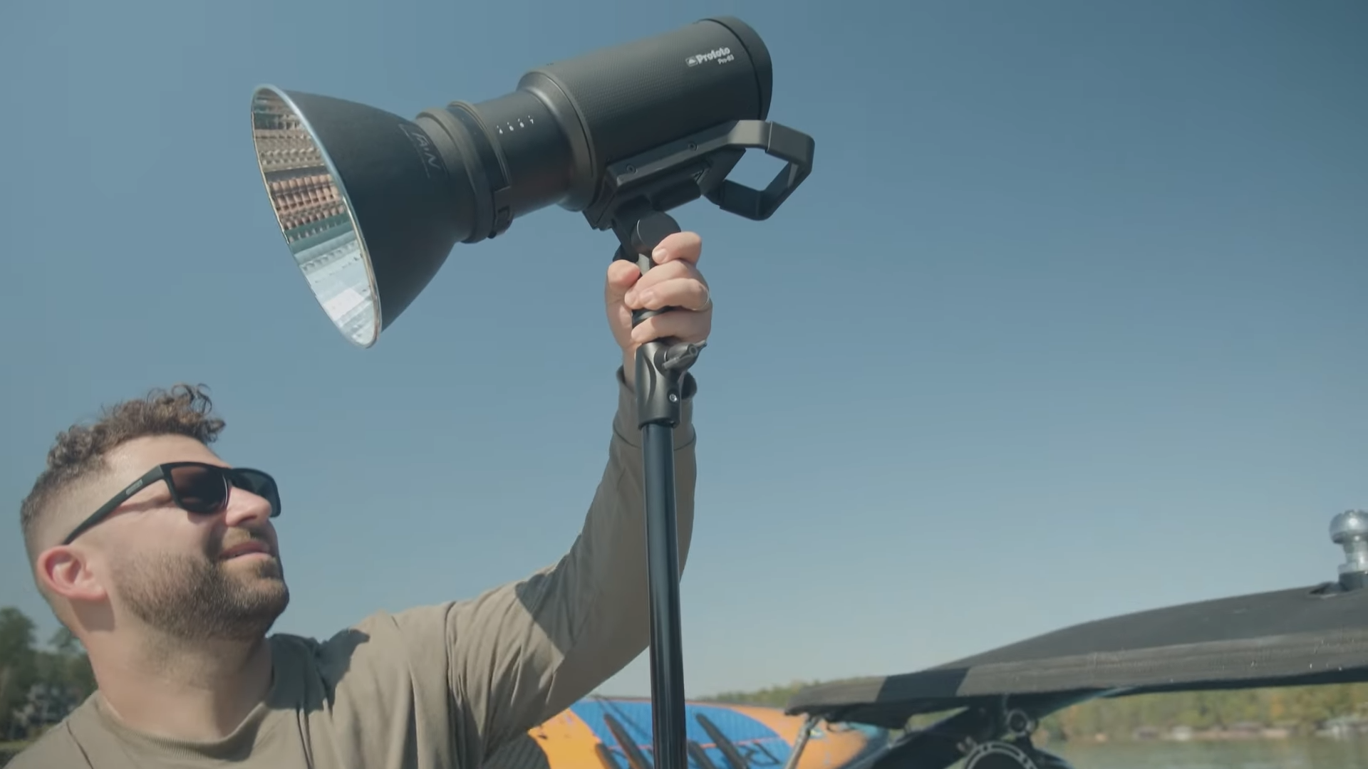 Photographer setting up Profoto Pro-B3 professional outdoor battery powered flash on a light stand outside for on location shoot