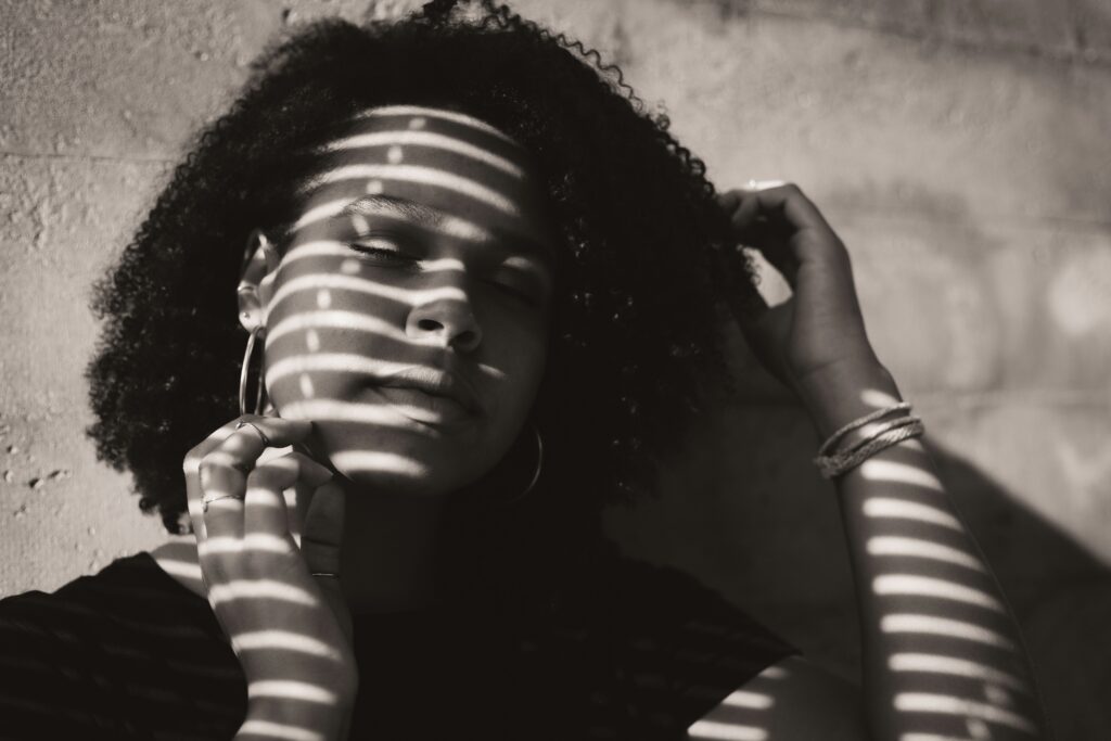 Portrait of a woman lit by light filtering through window blinds for gobo effect