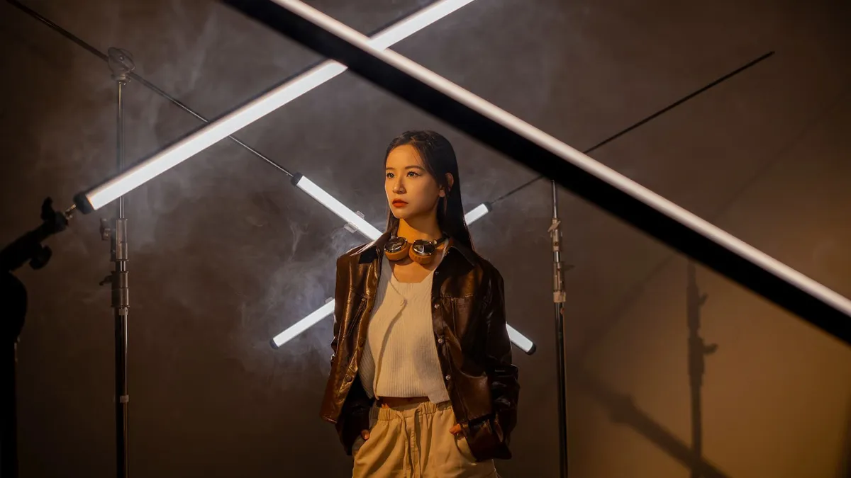 Model posing in a studio with Viltrox K90 RGB LED tube lights set up on light stands